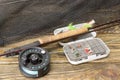 Fly fishing rod ,flie and a landing net on the old wooden table. All ready for fishing. Royalty Free Stock Photo