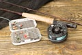 Fly fishing rod ,flie and a landing net on the old wooden table. All ready for fishing. Royalty Free Stock Photo