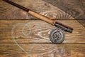 Fly fishing rod ,flie and a landing net on the old wooden table. All ready for fishing. Royalty Free Stock Photo