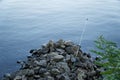 Fly fishing rod and reel on stone river bank. Fishing scene on the banks Royalty Free Stock Photo