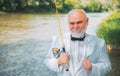 Fly fishing for trout. Brown trout being caught in fishing net. Portrait of cheerful man fishing. Fly angler man on the Royalty Free Stock Photo