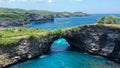 Fly over rock arch over ocean in Broken Beach, Nusa Penida, Indonesia. High quality 4k footage Royalty Free Stock Photo