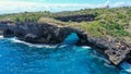 Fly over rock arch over ocean in Broken Beach, Nusa Penida, Indonesia. High quality 4k footage Royalty Free Stock Photo