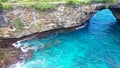 Fly over rock arch over ocean in Broken Beach, Nusa Penida, Indonesia. High quality 4k footage Royalty Free Stock Photo