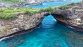 Fly over rock arch over ocean in Broken Beach, Nusa Penida, Indonesia. High quality 4k footage Royalty Free Stock Photo