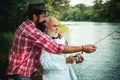 Fly rod and reel with a brown trout from a stream. Father and son relaxing together. Men fishing in river during summer Royalty Free Stock Photo