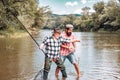 Fly rod and reel with a brown trout from a stream. Man fishing. Fly fisherman using fly fishing rod in beautiful river Royalty Free Stock Photo