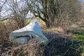 Fly tipping image of an old used mattress dumped in hedges