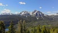 Fly through trees of a green Idaho forest towards McGown Peak in the Sawtooths