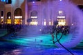 Flyboard rider in the swimming pool at night in the shopping avenue of the Land of legends complex