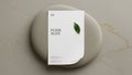 A5 flyer is placed on a smooth oval shaped light gray stone. Royalty Free Stock Photo