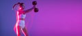 Flyer. Young sportive girl training with weights isolated on gradient blue-pink studio background in neon light. Sport