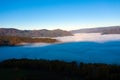 Flying above the clouds in dawn. Misty morning in the valley, aerial view