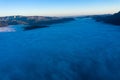 Flying above the clouds in dawn. Misty morning in the valley, aerial view