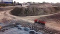 Flying above stone quarry with working heavy trucks and machines. Stock footage. Aerial view of industrial landscape