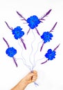 Flying abstract blue flowers on strings in male hand on white Royalty Free Stock Photo