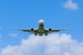 A flying airplane in blue sky with clouds