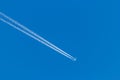 Flying airplane on a journey through the blue sky with a long white smoking exhaust plume and jetwash show international transport Royalty Free Stock Photo