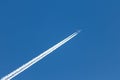 Flying airplane on a journey through the blue sky with a long white smoking exhaust plume and jetwash show international transport Royalty Free Stock Photo