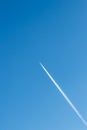 Flying airplane on a journey through the blue sky with a long white smoking exhaust plume and jetwash show international transport Royalty Free Stock Photo