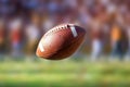 Flying American football ball with blurry stadium in background