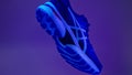 Creative shot of Asics Gel Nimbus running shoes with neon background