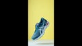Creative shot of Asics Gel Nimbus running shoes on yellow background