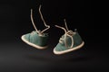 Flying baby shoes with laces on black background. Childhood concept with levitation effect