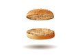 Flying, baked or grilled, cut in half burger bun sprinkled with sesame seeds. Isolated on white. Cooking and fast food