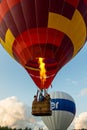 Flying balloon with passengers in a basket against the blue sky at the festival of Aeronautics summer evening in Pereslavl-Zalessk