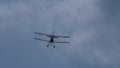 Flying biplane in the cloudy sky Royalty Free Stock Photo