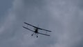 Flying biplane in the cloudy sky Royalty Free Stock Photo