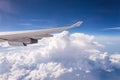 Flying into blue sky and sea of clouds and Wing of airplane with