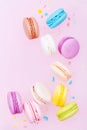 Flying cake macaron or macaroon on pink pastel background. Colorful almond cookies on dessert.