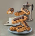 Flying chocolate eclairs near cup with espresso and coffee pot