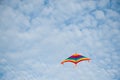 Flying colorful kite on cloudy blue sky background Royalty Free Stock Photo