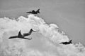 Flying combat aircraft against the blue sky with clouds on a sunny day