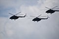 Flying combat helicopters against a blue sky with clouds on a sunny day