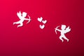 Flying cupid silhouette, happy Valentine`s Day banners, paper art style. Amour on red paper