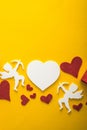 Flying cupid silhouette with hearts, happy Valentine`s Day banners, paper art style. Amour on yellow paper