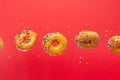 Flying donuts. Many donuts with colored caramel with sprinkles on a yellow background. Horizontal photo. Freezing in motion