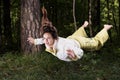 Flying in a dream. Young woman in pajamas in summer green forest