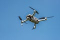 Flying drone with camera on a blue background with copy space. Airborne quadcopter. Also known as a drone or UAV.