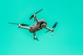 Flying Drone With Camera On Turquoise Background With Copy Space. Airborne Quadcopter. Also Known As A Drone Or UAV.