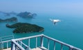 Flying Drone camera or UAV in the blue sky with ocean and island Royalty Free Stock Photo