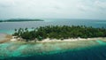 Flying a drone over a coral reef to a luxure resort island in the Maldives