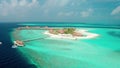 Flying a drone over a coral reef to a luxure resort island in the Maldives