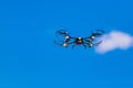 Flying drone or quad copter in clear blue sky