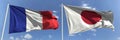 Flying flags of France and Japan on high flagpoles. 3d rendering