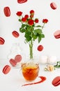 Flying food and still life. Breakfast desserts on white background with macaroons, bouquet of red roses and splashing tea